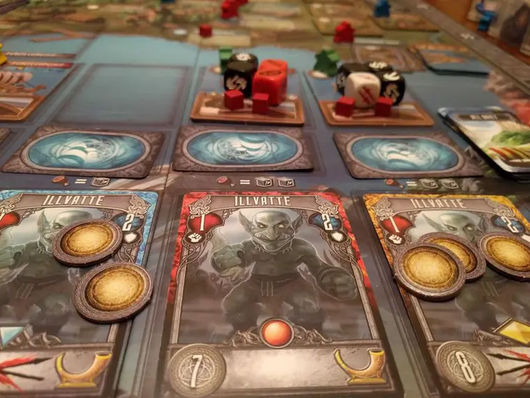 Cartas de monstruo con monedas y drakares con dados