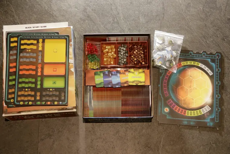 El tablero, los de jugador y la caja con cartas y cubos